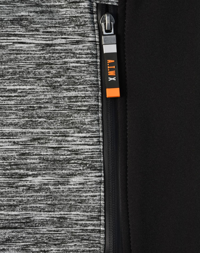A close-up of a grey and black workwear jacket featuring a zipper and a logo.