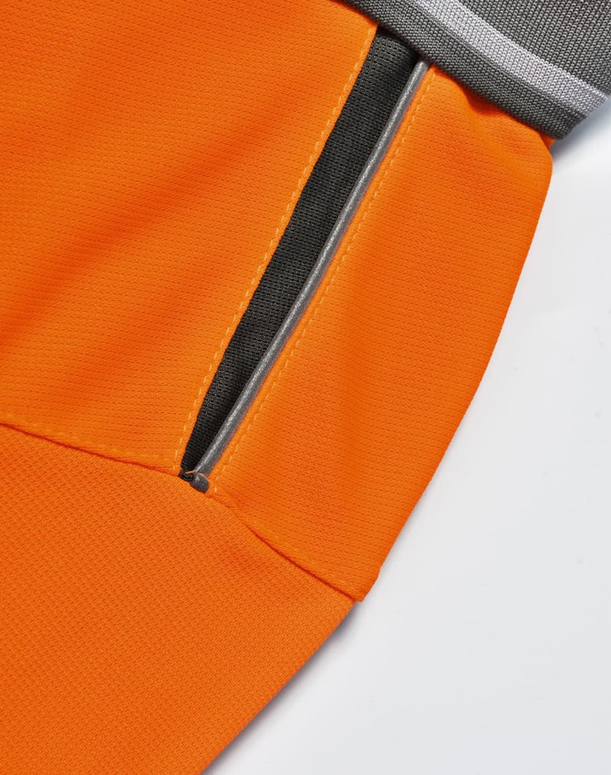 An orange polo shirt featuring a grey collar and a zippered pocket detail. The fabric has a textured finish.