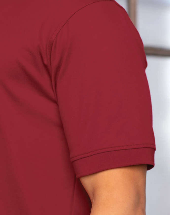 A maroon polo shirt with a short sleeve and a logo on the chest. The fabric appears smooth and lightweight.