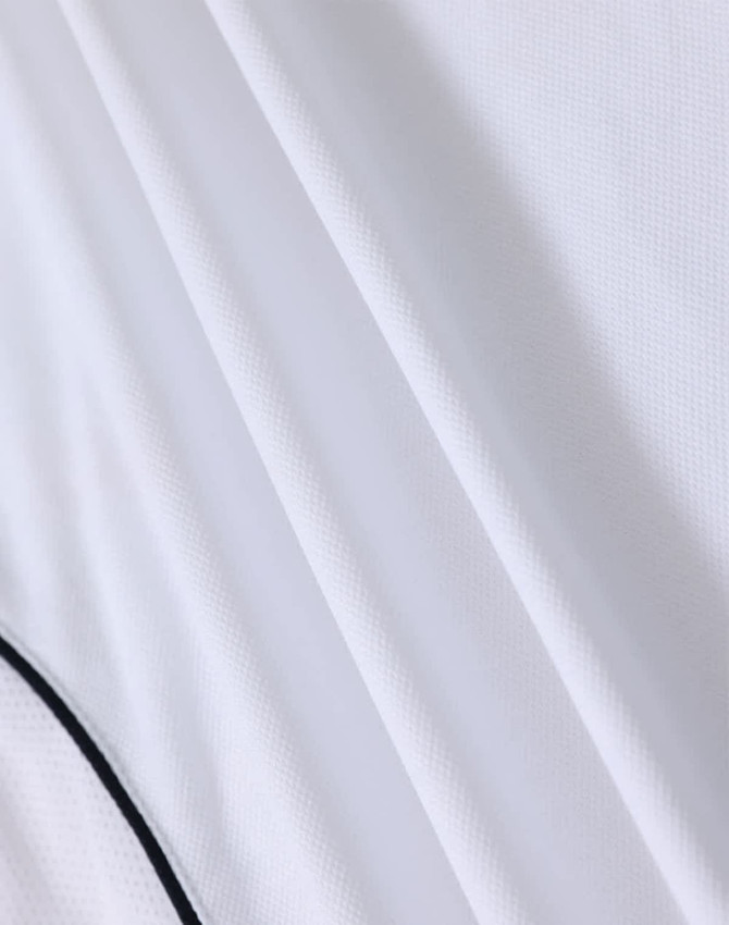 A white polo shirt with a textured fabric and contrasting detailing, featuring a logo.