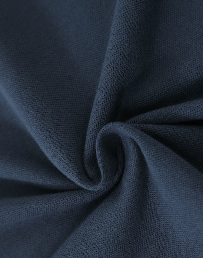 A close-up of navy cotton fabric with a stretch texture, showcasing its softness and weave.