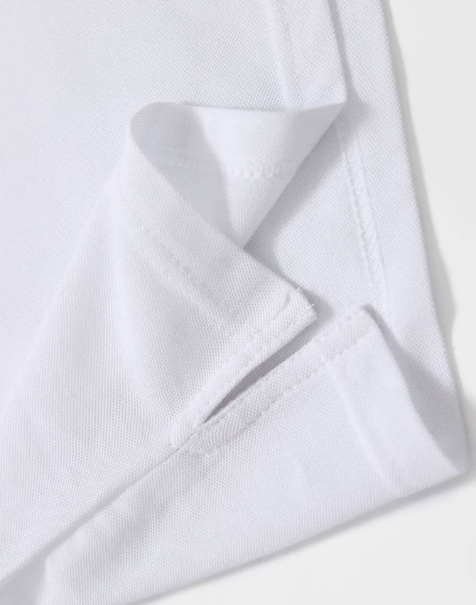 A close-up of a white polo shirt featuring a folded hem and a subtle logo.