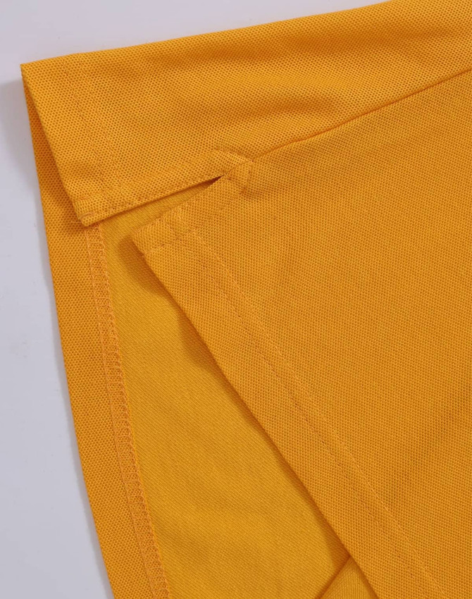 A close-up of a yellow polo shirt featuring folded sleeves and a logo.