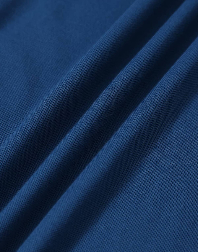 A close-up of a textured fabric in deep blue, featuring soft drapes and folds. The fabric is suitable for polo shirts.