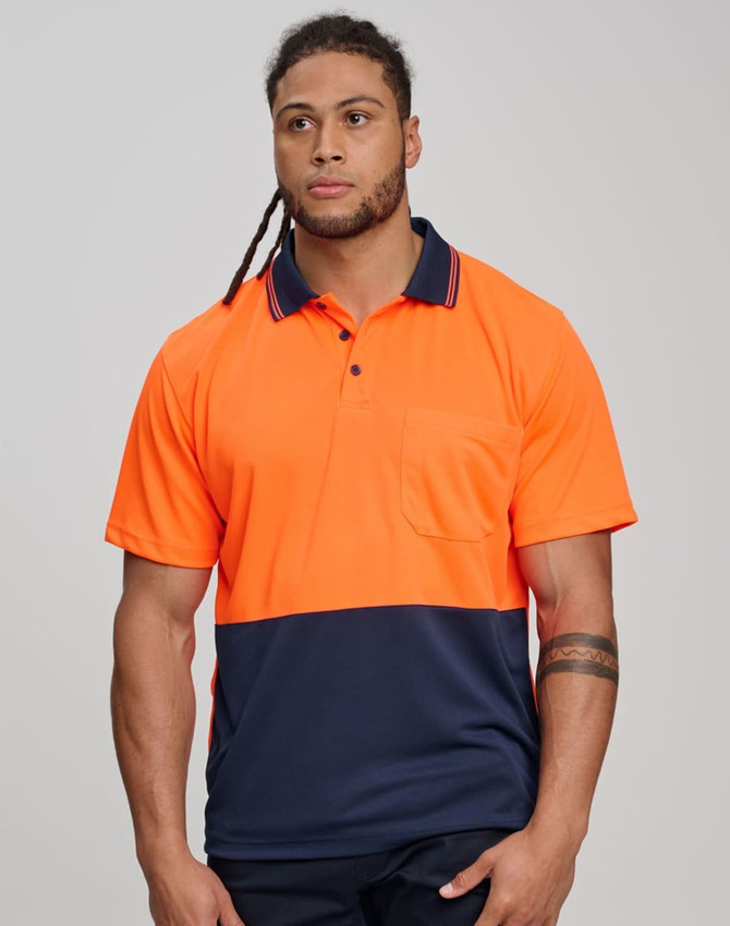 A man wears a high-visibility orange and navy short-sleeve safety polo shirt with a pocket. The shirt features a logo.
