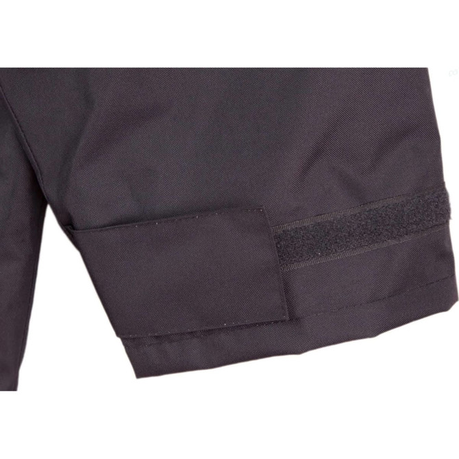A close-up of a black safety jacket featuring a Velcro patch and reflective 3M tape accents.