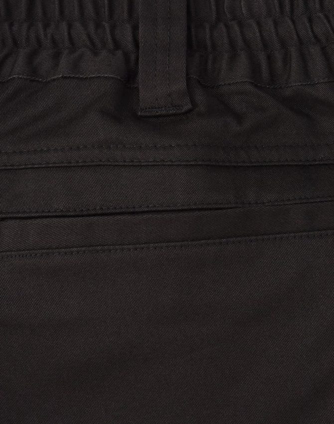 A close-up of black cotton stretch drill work shorts, featuring an elastic waistband and pockets.