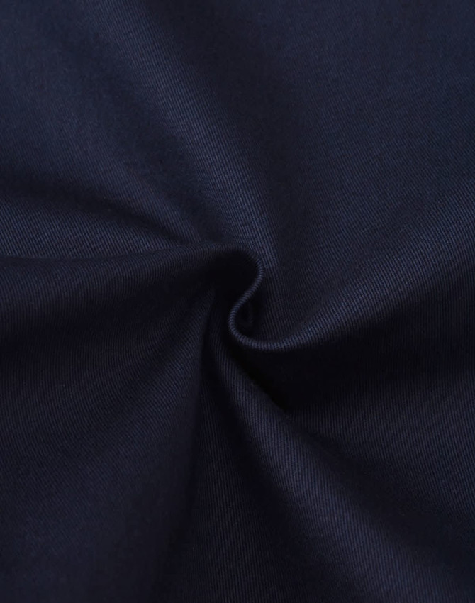 A close-up view of dark blue cotton fabric, showing its smooth texture and stretch quality.