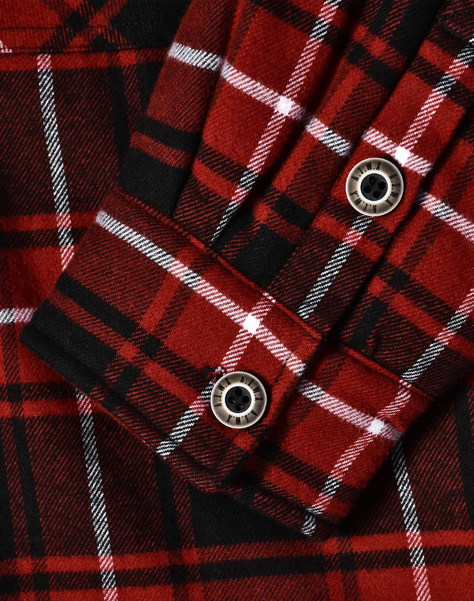 A close-up of a red and black quilted flannel shirt featuring a plaid pattern and button details.