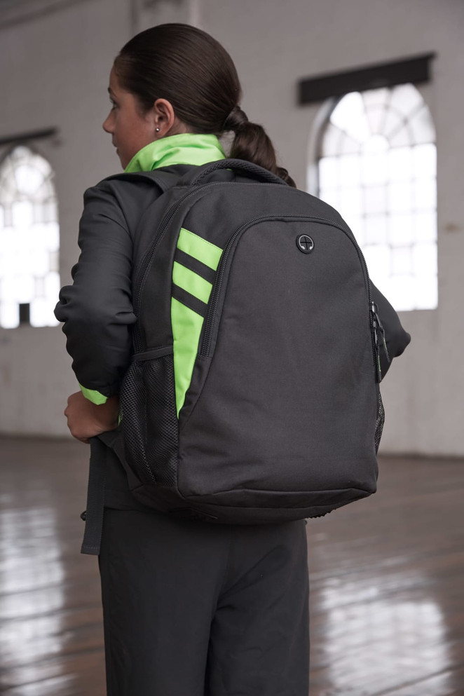 A black backpack with neon green accents is worn on a person's back, showcasing its sleek design.