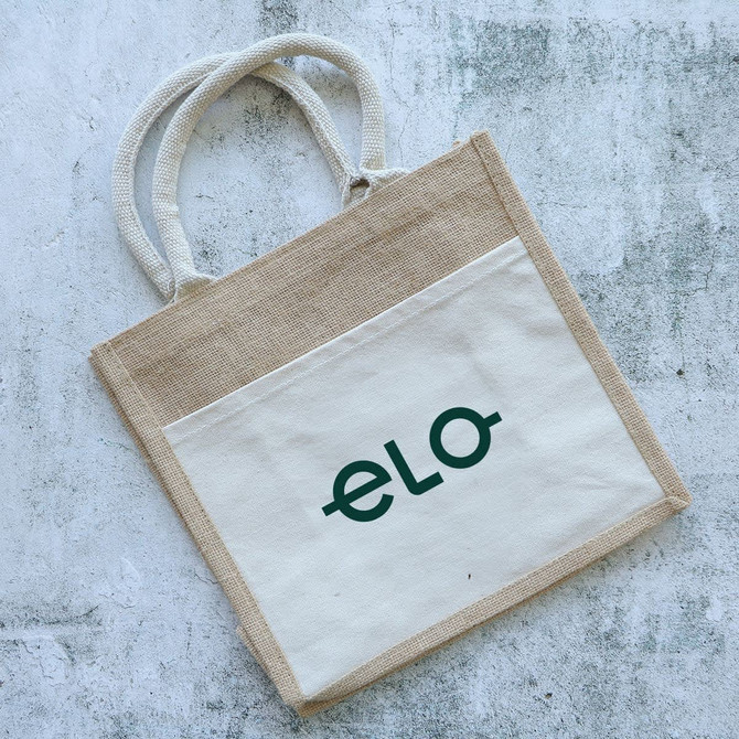 A jute tote bag in natural and cream colours with two handles and a logo on the front.