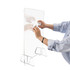 A clear personal protection screen held up with a hand wiping it clean, featuring a simple stand.