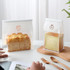A transparent sealing storage bag in white, containing fresh bread, alongside another smaller bag with cake.