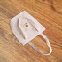 A natural-coloured, heavy-duty cotton tote bag with handles and a logo. The bag is placed on a wooden surface.