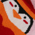 A knitted cover featuring a cheerful penguin design in vibrant red, orange, black, and white colours.