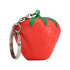 A red strawberry-shaped stress reliever attached to a silver keyring, featuring green leaves on top.