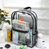 A transparent backpack in black with various items inside, including a laptop, books, and stationery.
