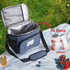 A cooler bag in blue, with interior capacity for 16 cans (330ml), featuring a front pocket and a shoulder strap.