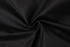 A close-up of black fabric with a textured surface, showcasing its smooth, twisted appearance.
