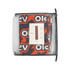 A small table runner in vibrant red and blue patterns, packaged in a clear zippered pouch, with a logo visible.