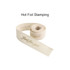 A rolled cotton ribbon in cream featuring gold hot stamping text. It has an elegant and soft appearance.