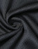 A close-up of black jacquard knit fabric, featuring a textured pattern and a subtle sheen, ideal for polo shirts.