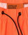 Bright orange lightweight nylon waterproof rain pants with an adjustable drawstring waistband and a branded label.