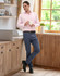 Men's flexi chino pants in navy blue, paired with a light pink shirt, standing in a kitchen setting.