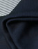 A close-up of textured, dark navy fabric with a ribbed pattern, showcasing its soft and flexible quality.