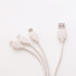 A square-shaped charging cable in white, featuring multiple connectors at one end and a logo on the connectors. A square-shaped charging cable in white, featuring multiple connectors at one end and a logo on the connectors.