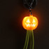 A bright orange pumpkin-shaped light with green charging cables, attached to a keyring, featuring a smiling face. A bright orange pumpkin-shaped light with green charging cables, attached to a keyring, featuring a smiling face.