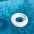 A white inflatable swim ring floating in clear blue water, featuring a subtle logo on its side.