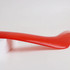 A V-shaped red boomerang toy resting on a white surface, showcasing its glossy finish.