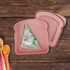 A pink portable lunch box shaped like a slice of bread, featuring a sandwich with filling inside.