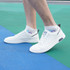 White ankle socks with a towel bottom design, worn with stylish white sneakers on a colourful floor.