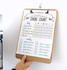 A wooden clipboard featuring a chore chart with colourful sections for daily and weekly tasks. It has a clip at the top. A wooden clipboard featuring a chore chart with colourful sections for daily and weekly tasks. It has a clip at the top.