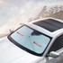 A white car shade umbrella with a logo, positioned on the windshield of a car in an outdoor setting.