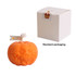 An orange pumpkin-shaped candle with a carved face, accompanied by a standard packaging box.