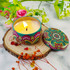 A decorative tin candle with a colourful floral design, surrounded by flowers and natural wood elements. A decorative tin candle with a colourful floral design, surrounded by flowers and natural wood elements.