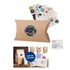A small brown kraft pillow box featuring a round logo and assorted stickers placed behind it.