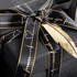A black ribbon with gold edges, featuring a heartbeat design and text, tied around a dark gift box.