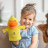 A yellow plush duck hand puppet with an orange beak, held by a smiling child. The puppet has a logo.