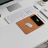 A cork wireless charger is placed on a desk alongside a white mouse, keyboard, and notebook. A cork wireless charger is placed on a desk alongside a white mouse, keyboard, and notebook.