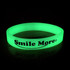 A green glow in the dark wristband with a logo, displayed against a dark background. A green glow in the dark wristband with a logo, displayed against a dark background.