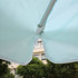 A mint green patio umbrella featuring valances, showing the underside and metal support structure.