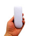 A hand holds a white, oval-shaped stress reliever. The item is smooth and has a minimalist design.