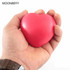 A red heart-shaped stress reliever held in a hand, featuring a smooth surface and a simple design.