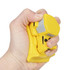 A yellow bulldozer-shaped stress reliever being squeezed by a hand. It features a simple design and a textured surface.