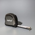A black tape measure with a retractable white measuring tape and a logo on the side.