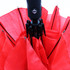 A red umbrella with a black handle and a logo, featuring multiple panels.